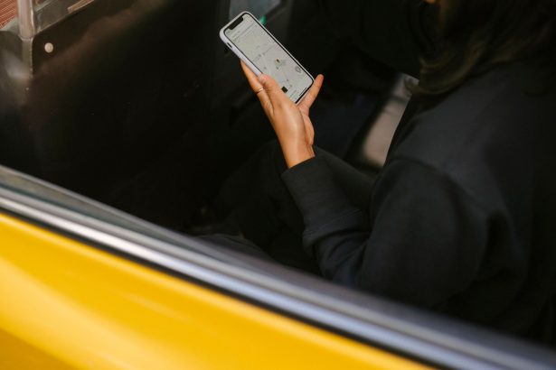 Passageira observa um aplicativo de mapas no celular enquanto viaja em um veículo de transporte.