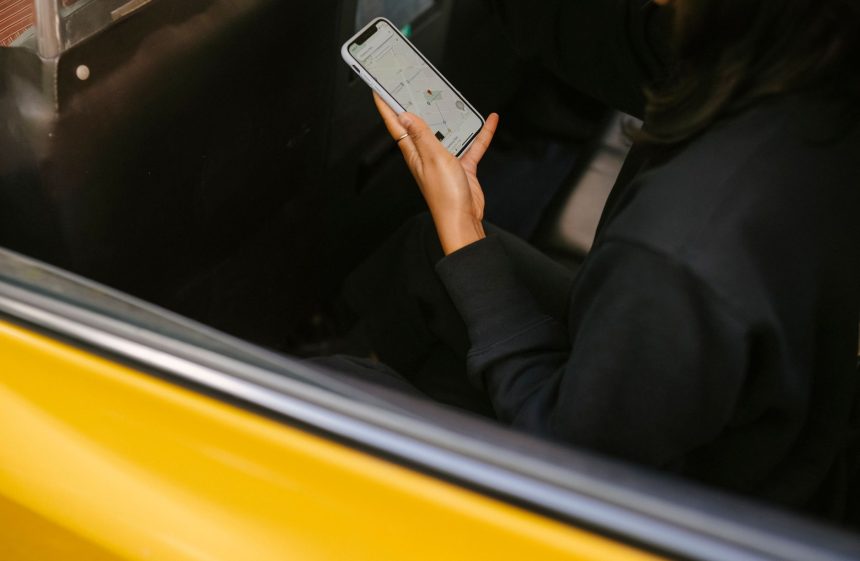 Passageira observa um aplicativo de mapas no celular enquanto viaja em um veículo de transporte.